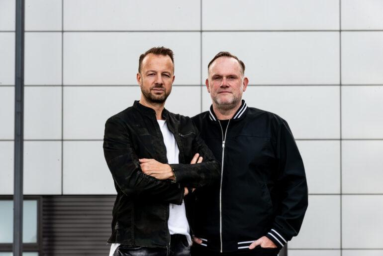 Detailansicht des Duos WIEGAND vor einer hellen Fassade. Promo für das Album "Arrived" 2023
